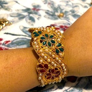 Gold tone bangle with multicolored stones